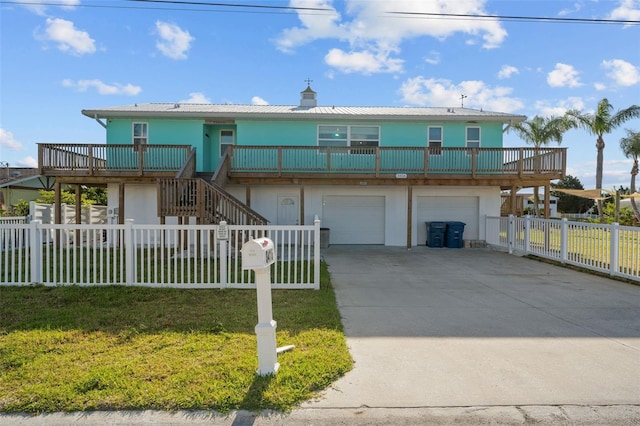 view of front of home with an attached garage, a front lawn, stucco siding, concrete driveway, and fence private yard