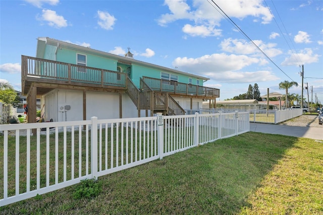 rear view of house with a yard, stairs, and a fenced backyard