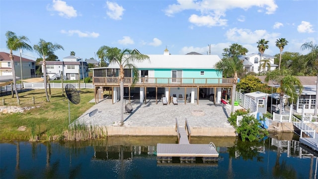 dock area with a deck with water view, a lawn, a residential view, a patio area, and a fenced backyard