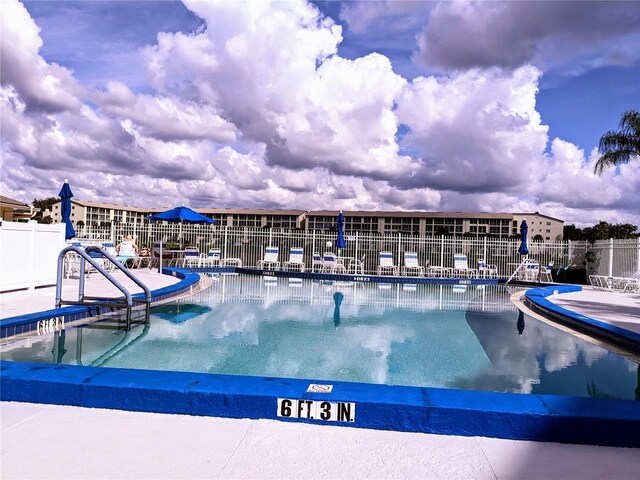 community pool featuring fence and a patio area