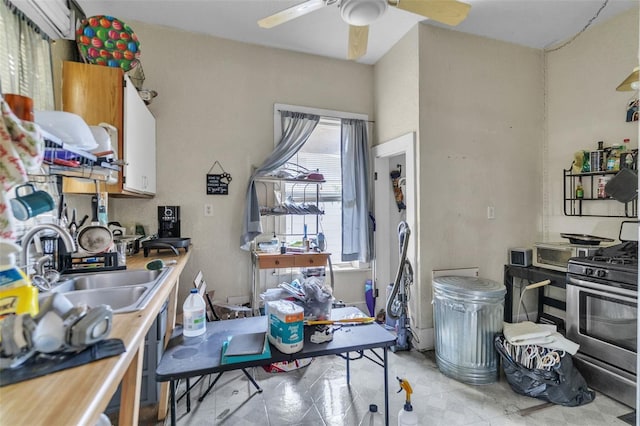 kitchen featuring a ceiling fan, a sink, and gas stove