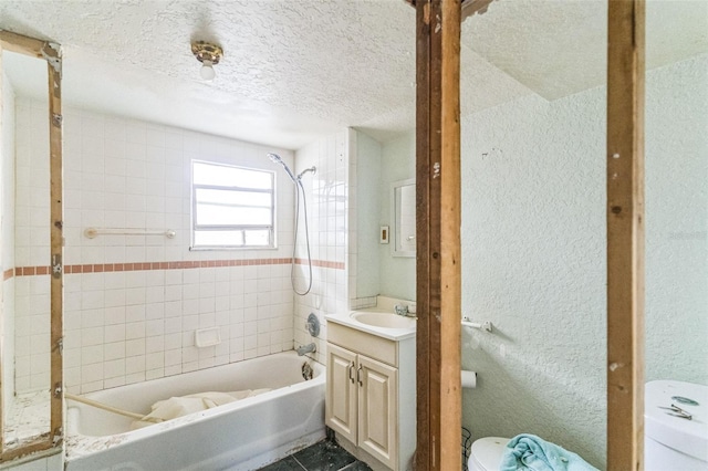 full bath with a textured wall, vanity, toilet, a textured ceiling, and shower / bath combination