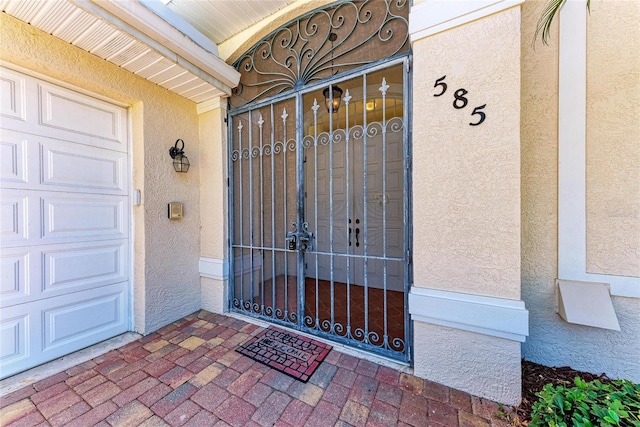 585 Khyber Ln, Venice, FL 34293 - doorway to property with stucco siding and a gate