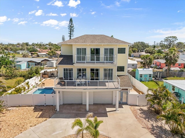 4717 Lemon Bay Dr, Venice, FL 34293 - back of house with an attached garage, a fenced backyard, a gate, concrete driveway, and a balcony