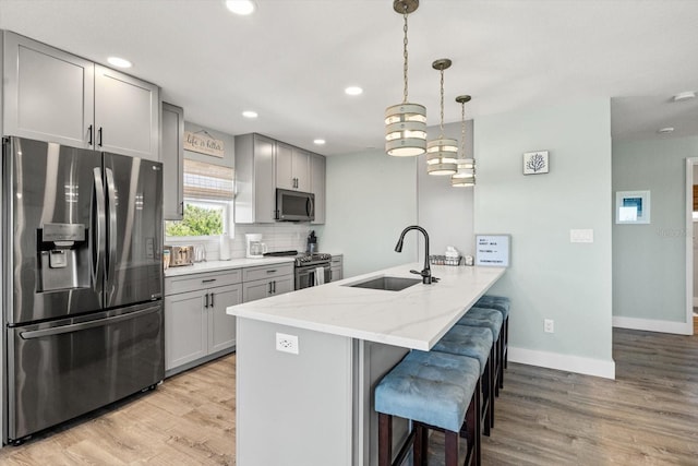 4717 Lemon Bay Dr, Venice, FL 34293 - kitchen featuring a breakfast bar area, appliances with stainless steel finishes, a sink, gray cabinetry, and a peninsula
