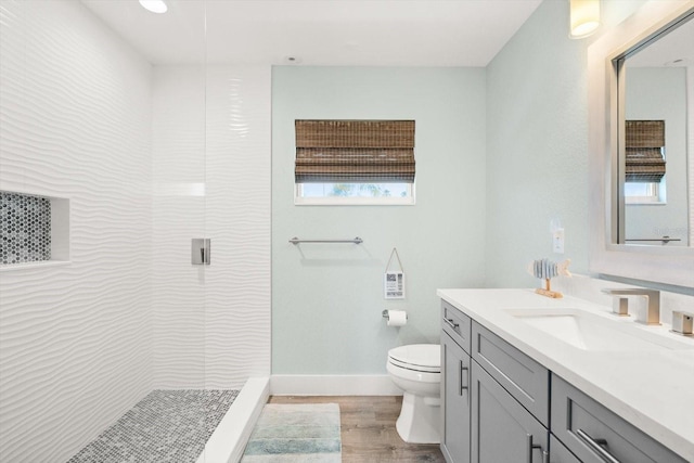 4717 Lemon Bay Dr, Venice, FL 34293 - bathroom featuring a tile shower, vanity, toilet, plenty of natural light, and wood finished floors