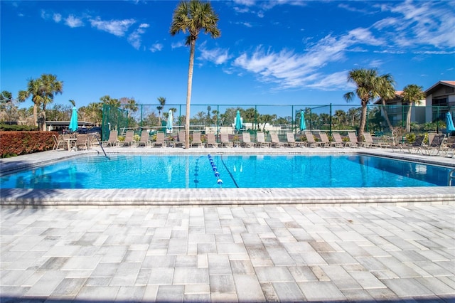 community pool with fence and a patio