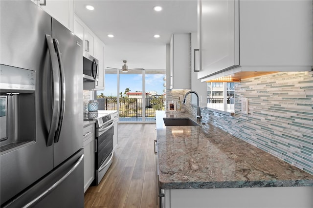 kitchen with ceiling fan, appliances with stainless steel finishes, decorative backsplash, and a sink