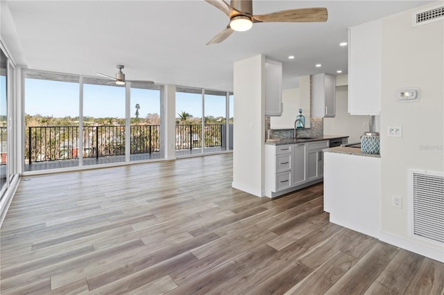 kitchen featuring plenty of natural light, a ceiling fan, light wood finished floors, and visible vents