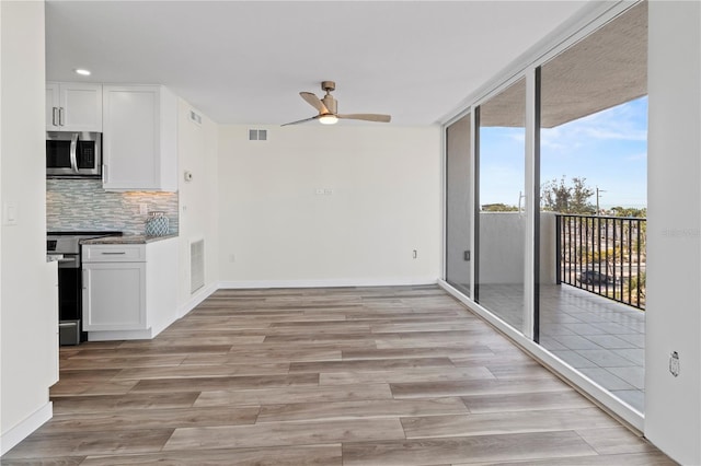 kitchen with white cabinets, appliances with stainless steel finishes, a ceiling fan, tasteful backsplash, and visible vents