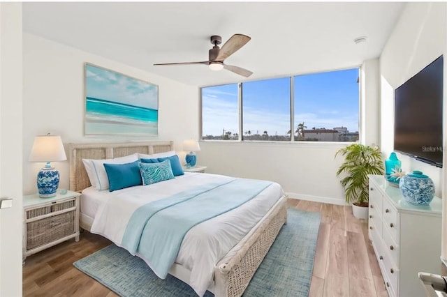 bedroom featuring baseboards, a ceiling fan, and wood finished floors