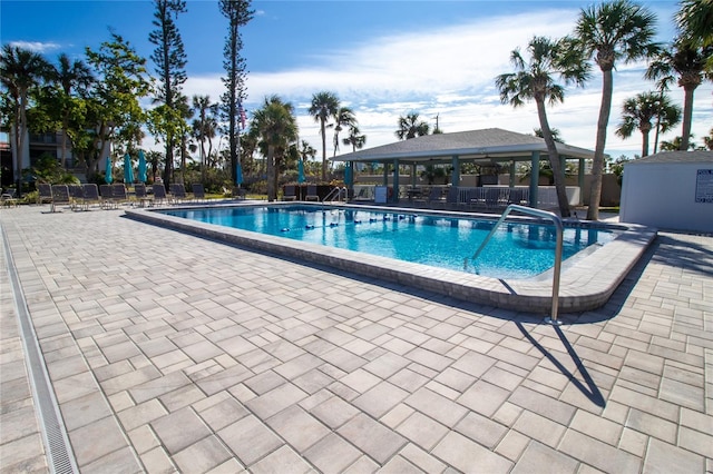 pool featuring fence, a gazebo, and a patio area