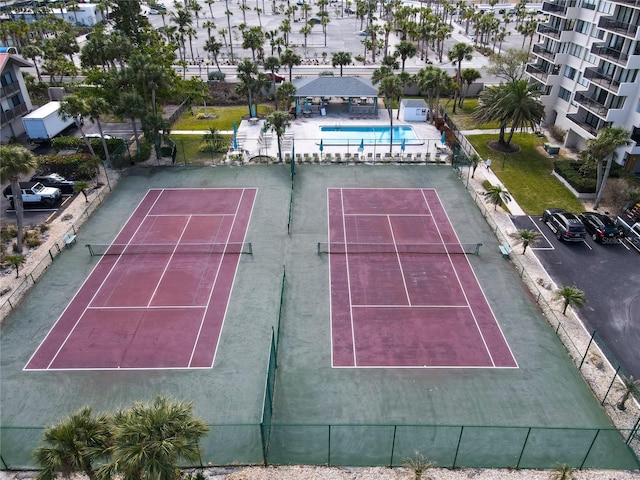 view of tennis court featuring a community pool and fence