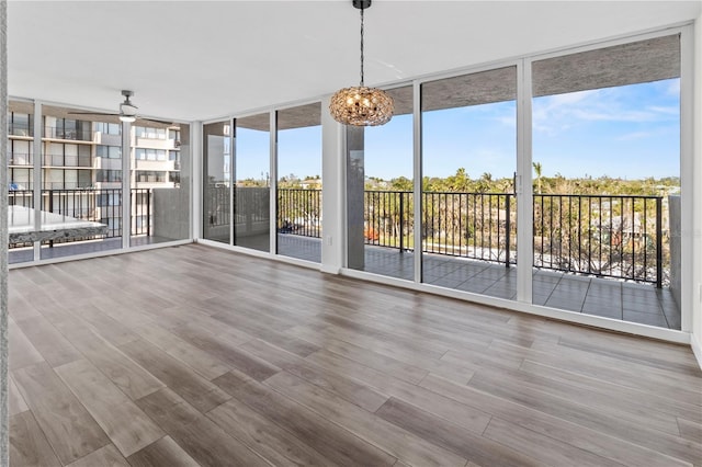 unfurnished sunroom with expansive windows, plenty of natural light, and wood finished floors