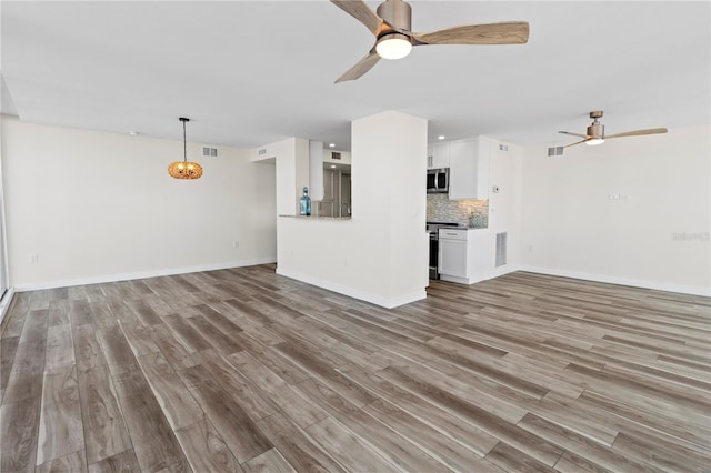 unfurnished living room featuring visible vents, a ceiling fan, light wood finished floors, and baseboards