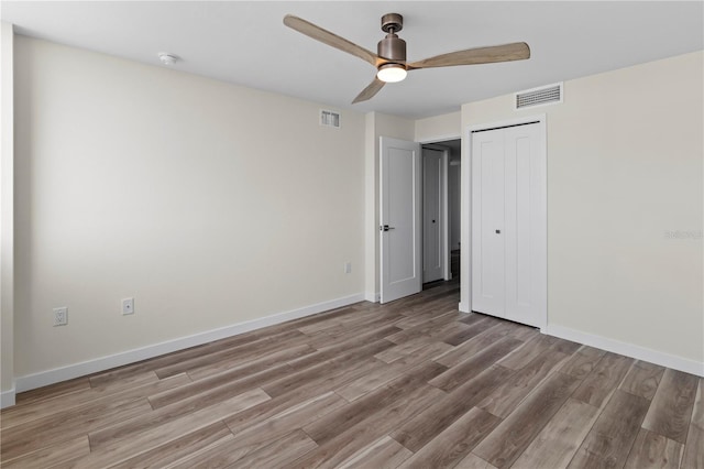 unfurnished bedroom with baseboards, light wood finished floors, and visible vents