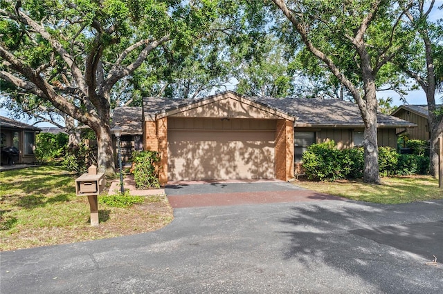 ranch-style home featuring a garage, brick siding, and driveway