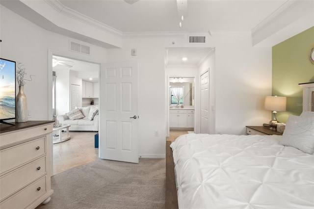 bedroom featuring ornamental molding, light colored carpet, ensuite bath, and baseboards