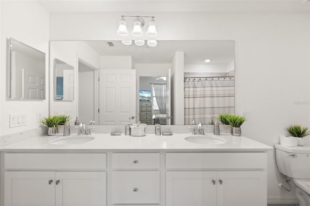 full bathroom with toilet, double vanity, and curtained shower