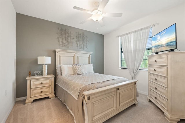 bedroom featuring light carpet, baseboards, and a ceiling fan
