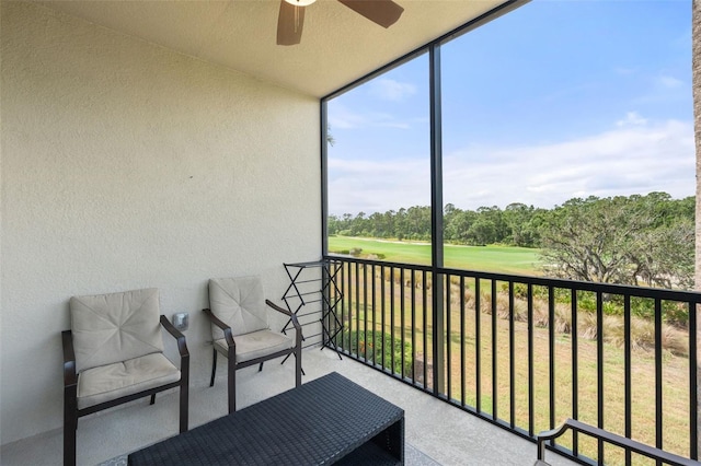 balcony featuring ceiling fan, view of golf course, and view of scattered trees