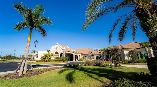 mediterranean / spanish-style home featuring a front lawn and stucco siding