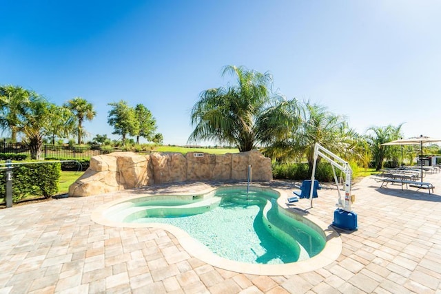 view of swimming pool with a patio area, fence, and a swimming pool