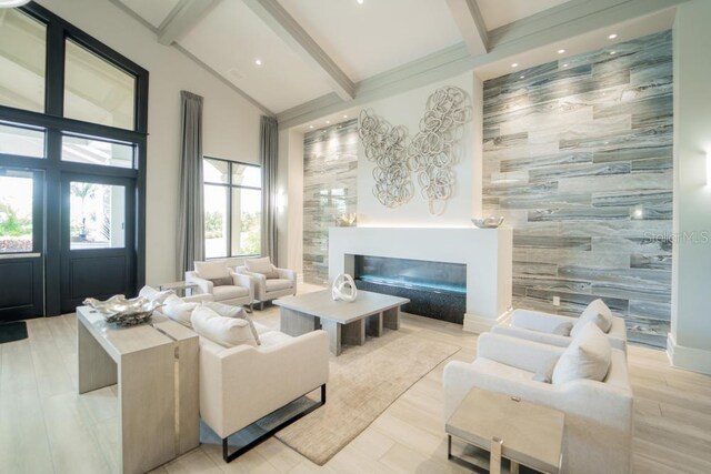 living area featuring an accent wall, a glass covered fireplace, tile walls, recessed lighting, and light wood-type flooring