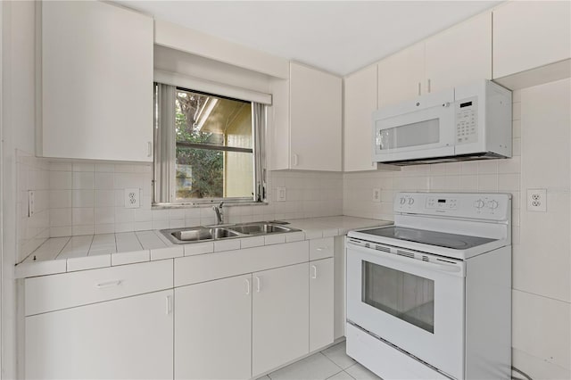 1802 Robinhood St, Sarasota, FL 34231 - kitchen with a sink, decorative backsplash, tile countertops, and white appliances