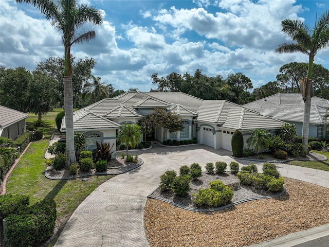 2111 Muskogee Trl, Nokomis, FL 34275 - mediterranean / spanish house with curved driveway, an attached garage, stucco siding, and a tiled roof