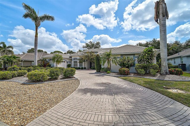 2111 Muskogee Trl, Nokomis, FL 34275 - mediterranean / spanish home featuring curved driveway, central AC, and stucco siding