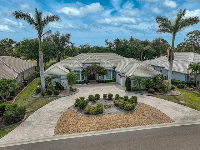2111 Muskogee Trl, Nokomis, FL 34275 - view of front facade featuring a garage, curved driveway, and a tile roof