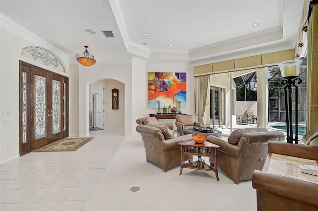 2111 Muskogee Trl, Nokomis, FL 34275 - living room with light tile patterned floors, a raised ceiling, crown molding, and arched walkways