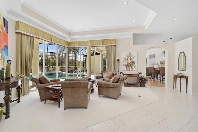 2111 Muskogee Trl, Nokomis, FL 34275 - living area featuring ornamental molding, light carpet, a raised ceiling, arched walkways, and light tile patterned floors