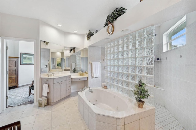 2111 Muskogee Trl, Nokomis, FL 34275 - bathroom with vanity, tile walls, a jetted tub, walk in shower, and tile patterned floors
