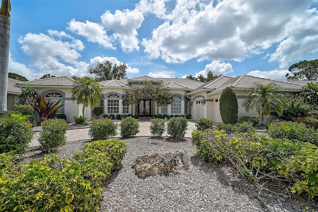 2111 Muskogee Trl, Nokomis, FL 34275 - mediterranean / spanish house featuring a tiled roof, stucco siding, and a garage