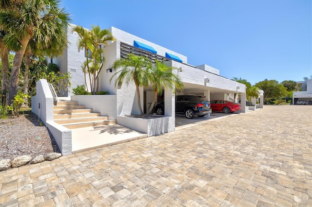 exterior space featuring covered parking and stucco siding