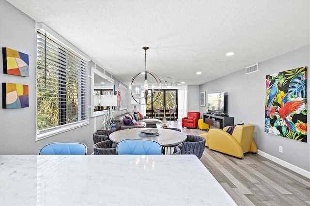 dining room with an inviting chandelier, wood finished floors, visible vents, baseboards, and recessed lighting