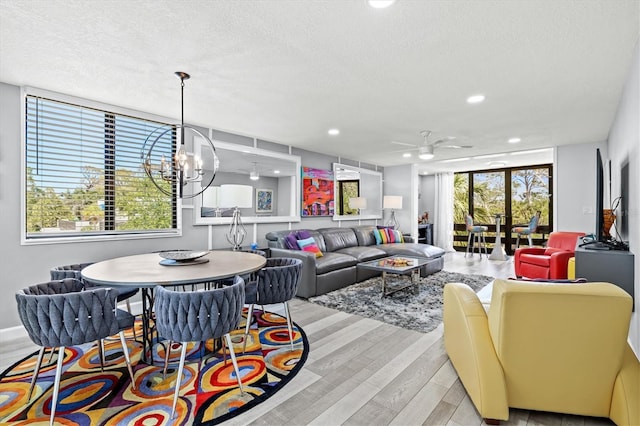 living area with a ceiling fan, light wood-style floors, recessed lighting, and a textured ceiling