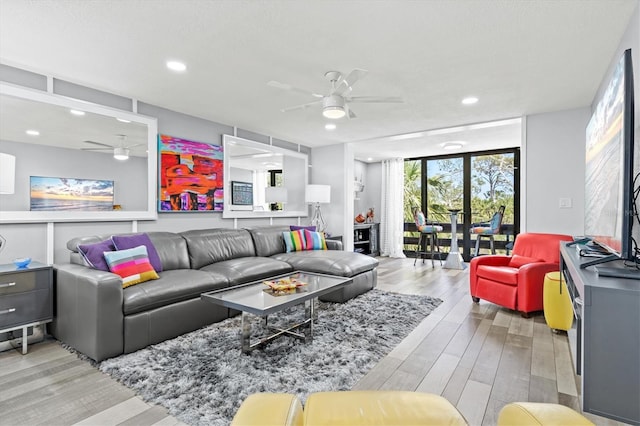living room featuring light wood-type flooring, ceiling fan, and recessed lighting