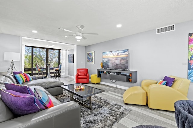 living room with baseboards, a ceiling fan, visible vents, and recessed lighting