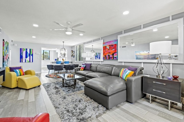 living room with ceiling fan with notable chandelier and recessed lighting
