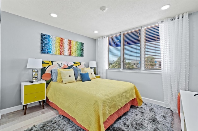 bedroom with a textured ceiling, baseboards, and recessed lighting