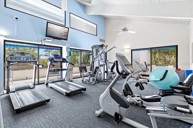 gym with carpet flooring, ceiling fan, and high vaulted ceiling