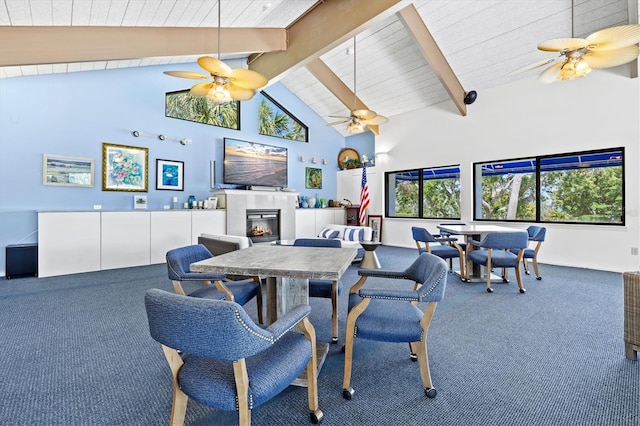 dining area featuring ceiling fan, carpet floors, high vaulted ceiling, and beam ceiling