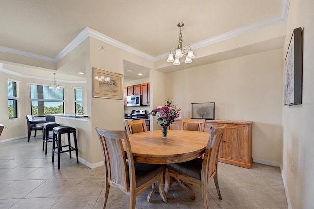 dining space with crown molding, baseboards, and a notable chandelier