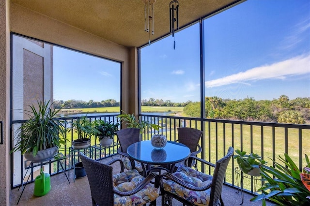 sunroom / solarium featuring a water view