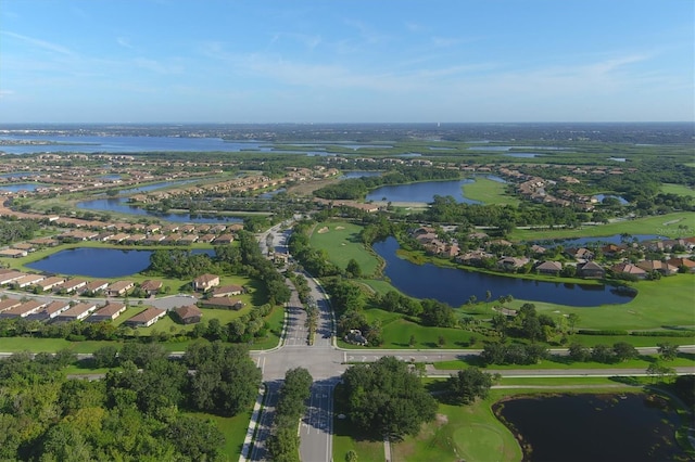 drone / aerial view with a water view, golf course view, and a residential view
