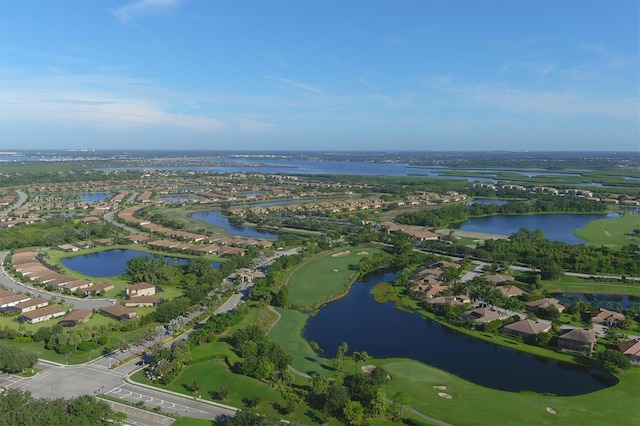 drone / aerial view featuring a water view, golf course view, and a residential view