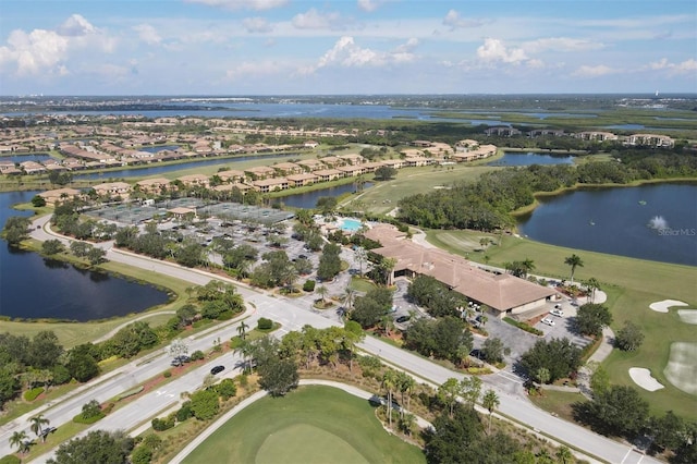 drone / aerial view with a water view, golf course view, and a residential view